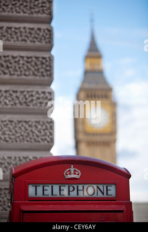 Una vista di un tradizionale telefono rosso scatola con il Big Ben a distanza Foto Stock