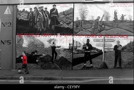 Ragazzo calci palla oltre la Shankill Road murale, Belfast, Irlanda del Nord, Regno Unito, BT13 2AA vicino Ballysillan Foto Stock