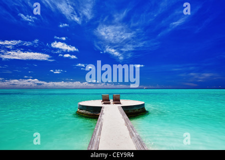 Due sedie a sdraio sulla incredibile vuoto spiaggia tropicale Foto Stock