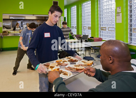 Alta scuola volontari servono la cena alla missione di salvataggio rifugio Foto Stock