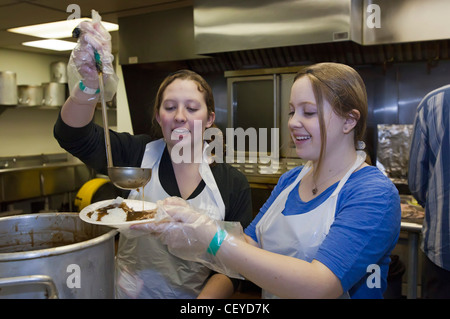 Alta scuola volontari servono la cena alla missione di salvataggio rifugio Foto Stock