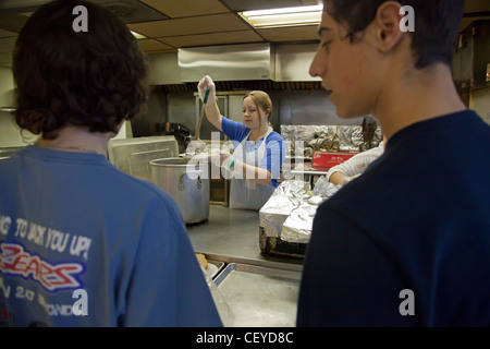 Alta scuola volontari servono la cena alla missione di salvataggio rifugio Foto Stock