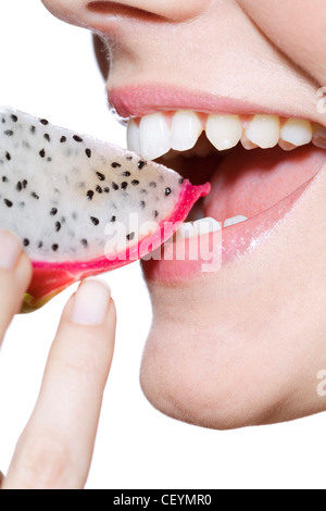 Femmina rosa da indossare lucidalabbra, mangiando un cuneo di frutta Drago Foto Stock
