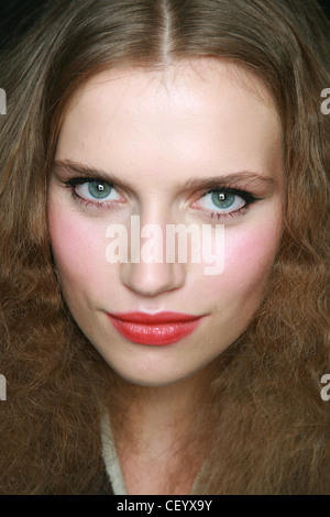 Modello con scuri lunghi capelli biondi con mediana di separazione indossando grassetto nero eyeliner, mascara nero, blusher rosa e rosso lucidalabbra Foto Stock