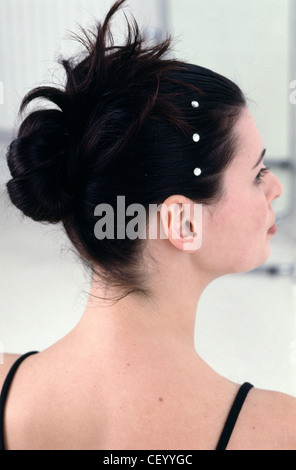 Passo per passo i capelli Updo femmina con brunette capelli intrecciati in un chignon e decorato con cristalli di diamante Foto Stock