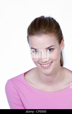 Femmina con capelli castani fuori la sua faccia, indossando un top lilla, sorridente, guardando la fotocamera Foto Stock