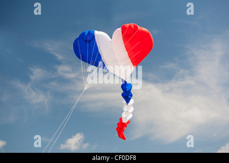 Forma di cuore kite in rosso bianco e blu vola alto nel cielo blu Foto Stock