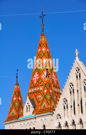 Vivacemente colorato guglia della chiesa di San Mattia, il quartiere del Castello di Buda, Budapest, Ungheria mostra aereo sentiero di vapore nel cielo blu Foto Stock