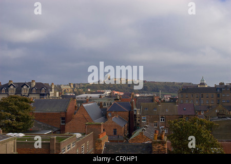 Città di Scarborough con il castello sul promontorio roccioso dietro in un giorno nuvoloso Foto Stock
