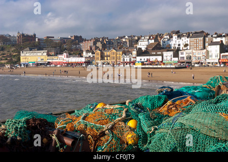 La spiaggia a Scarborough in Yorkshire con gente camminare lungo sulla sabbia e la città in background Foto Stock