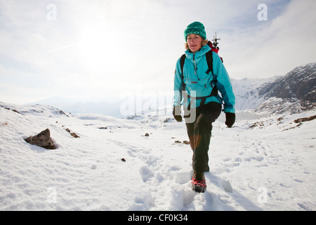 Una donna hill walker al di sopra di un congelati Stickle Tarn in Langdales, Lake District, REGNO UNITO Foto Stock