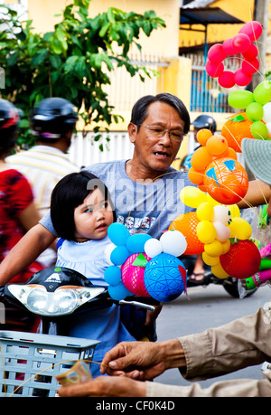 Un padre acquisto di sua figlia palloncini dopo la scuola in Hoi An, Vietnam Foto Stock