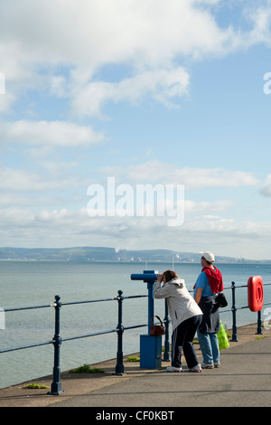 Un giovane che guarda al mare sul lungomare, Mumbles, Galles Foto Stock