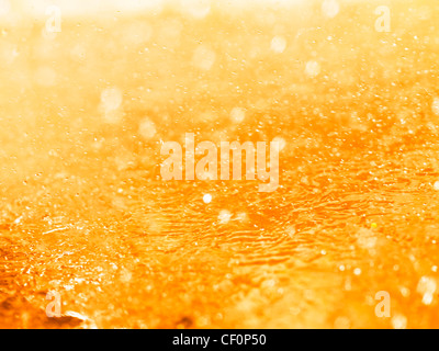 Orange gli spruzzi di liquido closeup abstract texture di sfondo Foto Stock