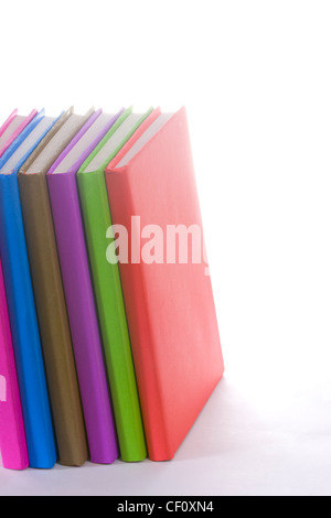 Pila di coloratissimi libri reali su bianco Foto Stock