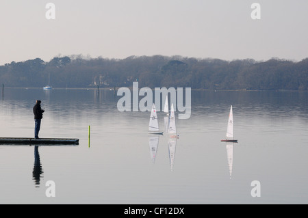 L'uomo sul pontile in legno il controllo remoto modello controllato yachts. Chichester Marnina. L'inverno. Foto Stock