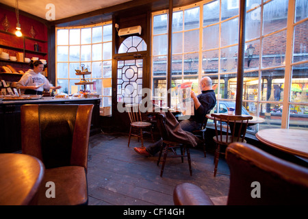 Un uomo si rilassa in farmacia cafe in Rye East Sussex Foto Stock