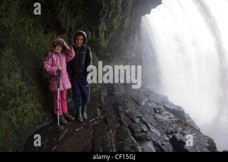 Camminare dietro il sipario di Scwd yr Eira (o Sgwd yr Eira) cascata sul Afon Hepste nel Parco Nazionale di Brecon Beacons Foto Stock