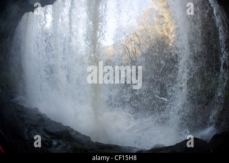 Camminare dietro il sipario di Scwd yr Eira (o Sgwd yr Eira) cascata sul Afon Hepste nel Parco Nazionale di Brecon Beacons Foto Stock