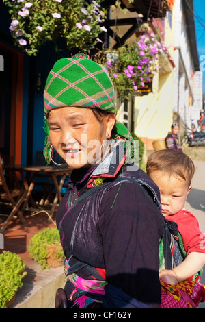 Nero donna Hmong bambino portando sulla sua schiena, SAPA, Vietnam Foto Stock