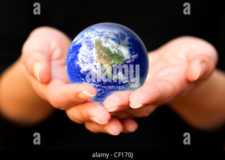 Le mani umane tenendo attentamente il pianeta Terra. Mondo di vetro Foto Stock