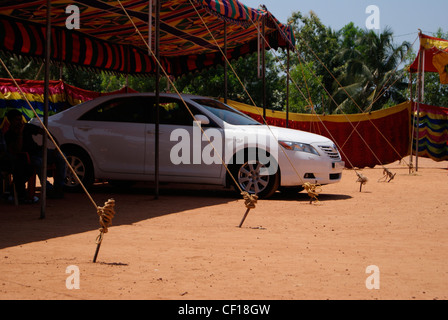 Auto parcheggiate in tenda aperta. Una scena dal Kerala, India. Toyota Camry bianco auto è all'interno della tenda per il parcheggio. Foto Stock