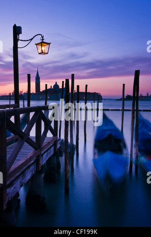 Gondole attraccate da piazza San Marco all'alba con San Giorgio di maggiore chiesa al di là - Venezia, Venezia, Italia e Europa Foto Stock