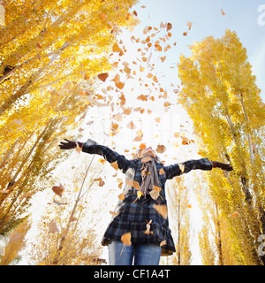 La donna caucasica giocando con foglie di autunno Foto Stock