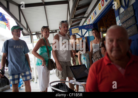 Turisti francesi, in piedi, e i residenti stranieri si raccolgono in una caffetteria locale in Clifton, Union Island. Foto Stock