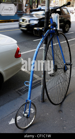 Un penny farthing bicicletta parcheggiata in una strada Foto Stock