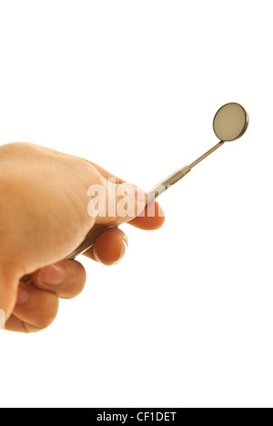 Mano che regge lo specchio utensile dentale isolati su sfondo bianco Foto Stock