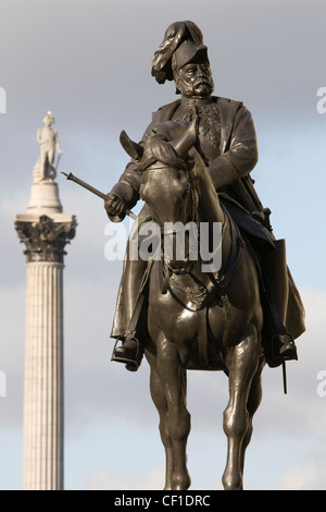 Un bellicoso statua equestre di Prince George, duca di Cambridge in Whitehall con Nelson permanente di colonna in Trafalgar Square Foto Stock