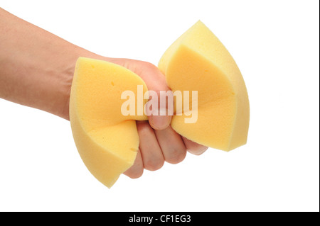 Mano umana la spremitura di un giallo Spugna per pulizia Foto Stock