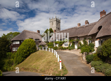 Il Regno Unito, l'Inghilterra, l'Isola di Wight, Godshill, Chiesa di tutti i santi in piedi sulla collina sopra idilliaco cottage con il tetto di paglia Foto Stock