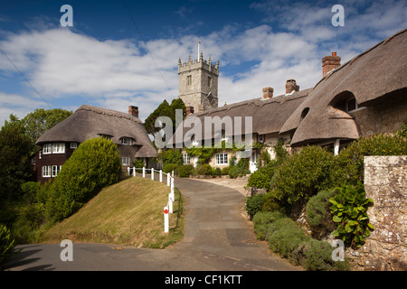 Il Regno Unito, l'Inghilterra, l'Isola di Wight, Godshill, Chiesa di tutti i santi in piedi sulla collina sopra idilliaco cottage con il tetto di paglia Foto Stock