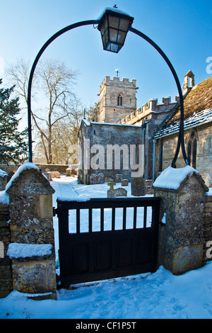 Vista nevoso attraverso la porta della chiesa del Santo di Rood o Croce nel villaggio Costwold di Ampney Crucis, Gloucestershire, England, Regno Unito Foto Stock