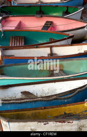 Una fila di colorate imbarcazioni a remi vicino al fiume a Leigh-on-Sea. Foto Stock