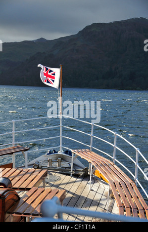 Bandiera sulla prua di una traversata in traghetto Lago di Ullswater in inverno da Glenridding al ponte Pooley,Lake District,Cumbria, Inghilterra Foto Stock