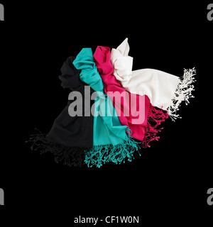 Ancora un colpo di vita di colorate sciarpe di lana allineate su uno sfondo nero Foto Stock