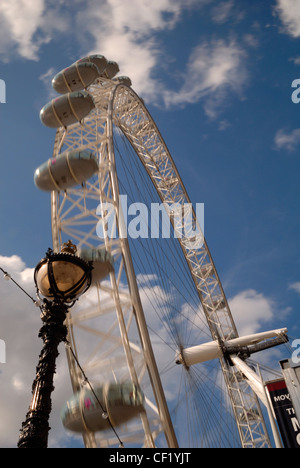 Il London Eye in movimento con il lampione vittoriano in primo piano. Foto Stock