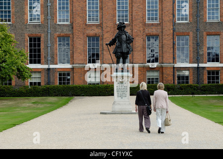 Due turisti in cammino verso la statua di Guglielmo III di fronte a Kensington Palace. Kensington Palace è stato originariamente Nottingha Foto Stock
