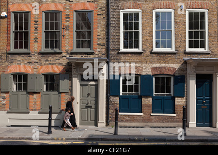 Una madre e figlia a piedi passato XVIII secolo case cittadine Georgiane su Fournier Street nell'East End di Londra. Foto Stock