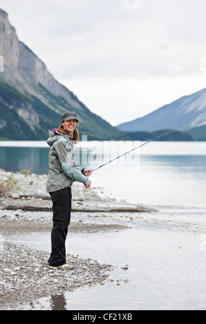 La donna caucasica la pesca in Lago Maligne Foto Stock