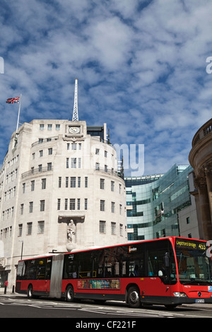 Un bus articolato (bendy bus) passando Broadcasting House, della BBC la sede aziendale. Foto Stock