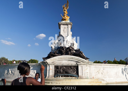 Una giovane donna di fotografare la regina Victoria Memorial fuori Buckingham Palace. Foto Stock