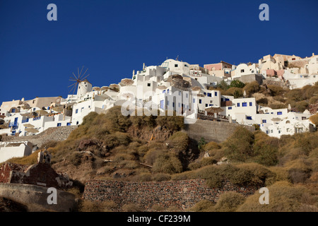 Una vista guardando verso il greco tradizionale villaggio di Oia arroccato sulle scogliere al di sopra della caldera di Santorini Foto Stock