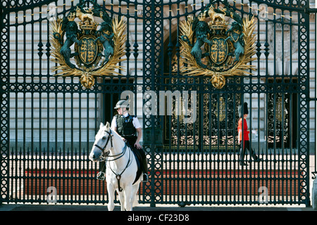 È montato un funzionario di polizia e una regina della guardia di turno fuori Buckingham Palace. Foto Stock