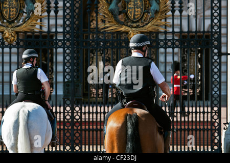 Montate i funzionari di polizia e una regina della guardia di turno fuori Buckingham Palace. Foto Stock