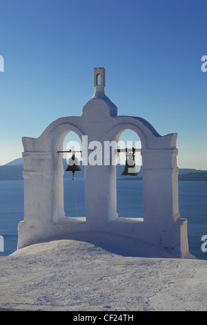 Una vista di una torre campanaria appollaiato sul tetto di una chiesa ortodossa greca nel villaggio di Oia Foto Stock