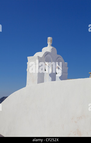 Una vista di una torre campanaria appollaiato sul tetto di una chiesa ortodossa greca insieme contro un cielo blu Foto Stock